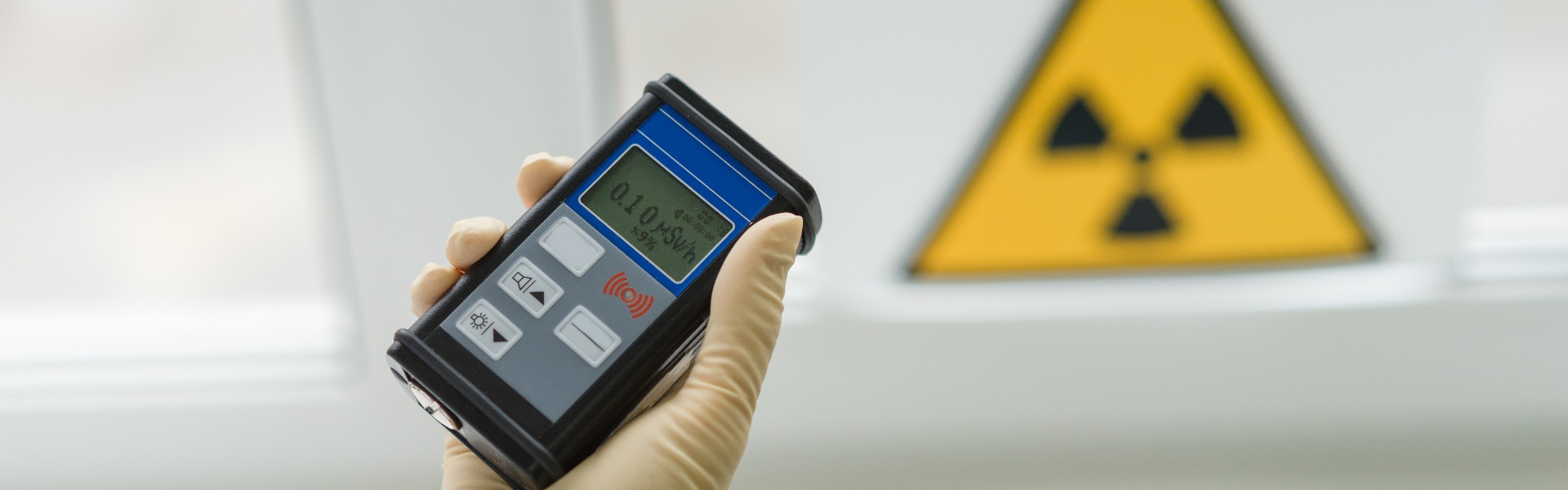 the scientist keeps a dosimeter in his hand to measure the level of radioactive contamination