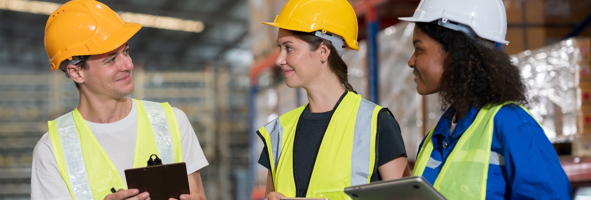 Male and female warehouse workers working and standing talking together at the storage warehouse. Group of warehouse workers discuss and training work in distribution branch